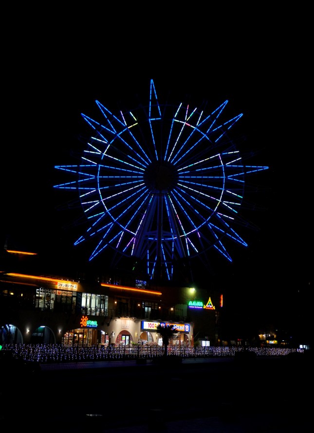 The ferris wheel lit at night in Mihama American Village in Chatan, Okinawa, Japan.