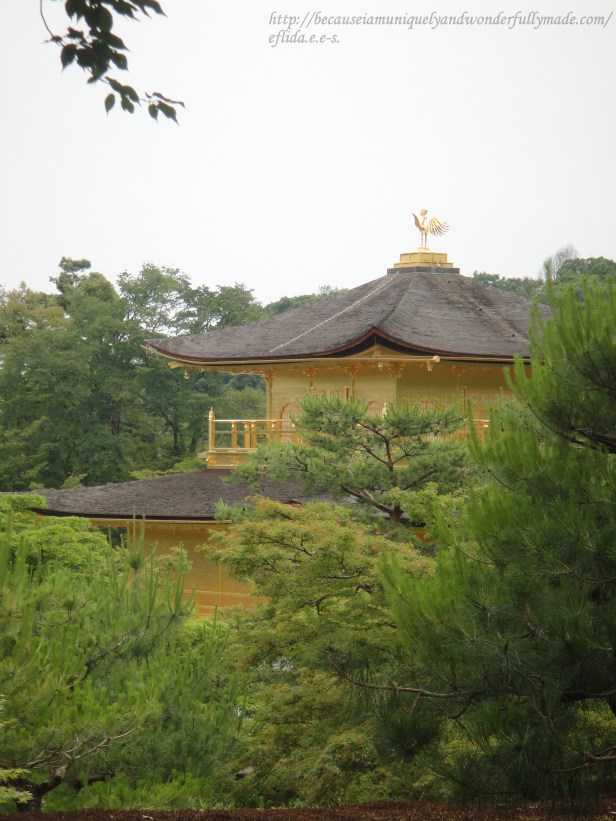 A peak of the third and topmost floor of Kinkaku whic is in Chinese Zen style capped with a golden phoenix.