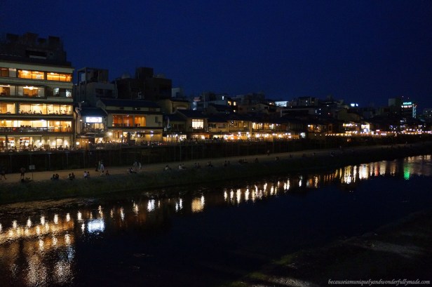The beautiful Kamo River 鴨川 lined with romantically-lit restaurants viewed over at  Shijo Ohashi 日本語 in Kyoto, Japan.