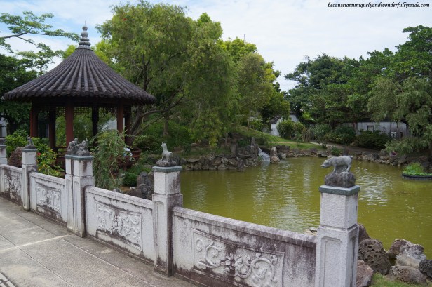The pond and gazebo and some parts of the small bridge with Chinese animals signs at Fukushuen Garden 福州園 in downtown Naha 那覇市 Okinawa 沖縄本島,  Japan 日本国.