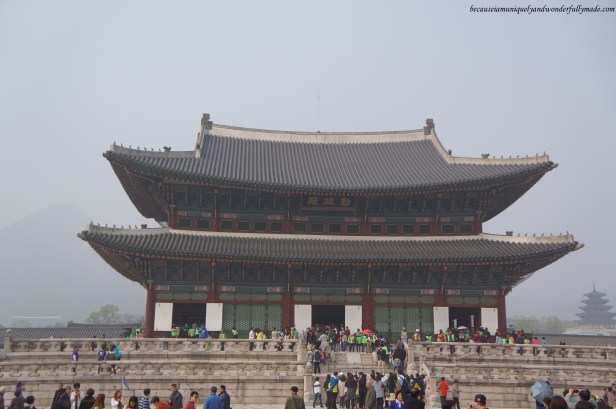 Full view of Geunjeongjeon Hall 근정전 and a gathering tourists at Gyeongbokgung Palace 경복궁 in Seoul, South Korea.