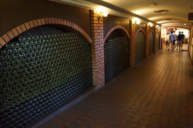 Wall of empty wine bottles at Nago Pineapple Park in Okinawa, Japan.